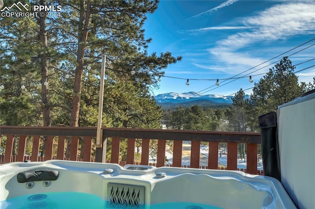 exterior space with a mountain view and a hot tub