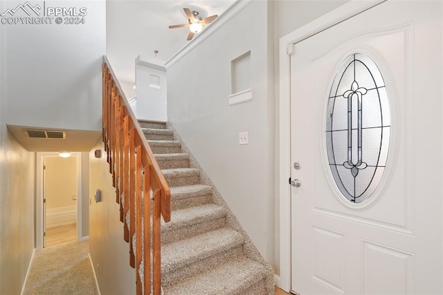 foyer featuring ceiling fan and light colored carpet