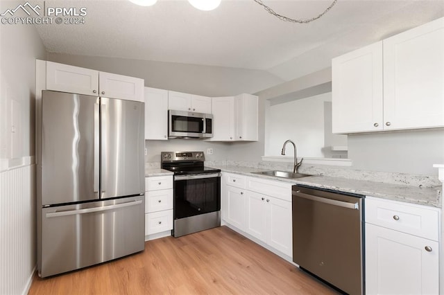 kitchen featuring sink, white cabinets, stainless steel appliances, and vaulted ceiling