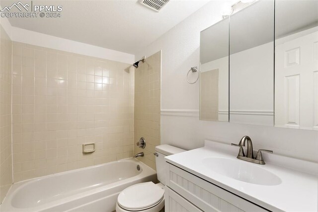 full bathroom featuring vanity, toilet, and tiled shower / bath