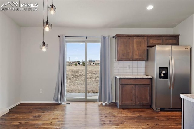 kitchen with pendant lighting, dark hardwood / wood-style floors, backsplash, and stainless steel refrigerator with ice dispenser