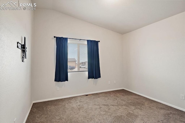 spare room featuring carpet and lofted ceiling