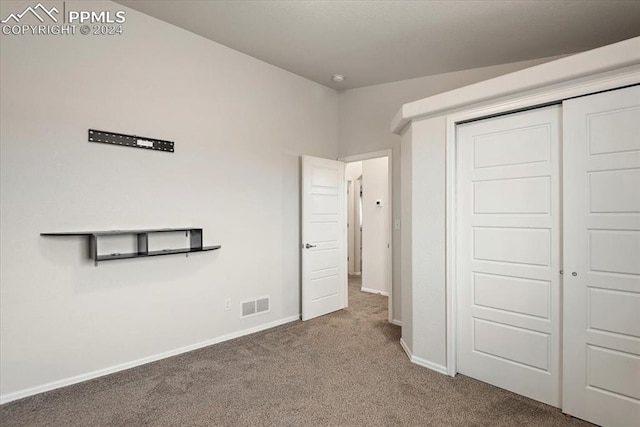 unfurnished bedroom featuring carpet and a closet