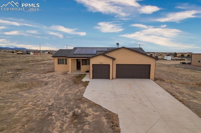 view of front of property featuring a garage and solar panels