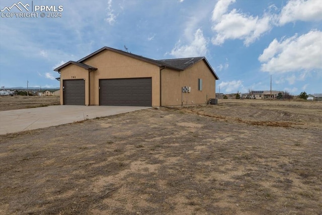 view of home's exterior with a garage and central AC unit