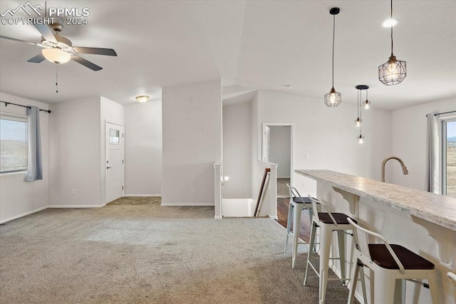 kitchen featuring a kitchen bar, decorative light fixtures, plenty of natural light, and ceiling fan