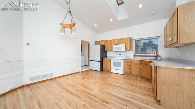 kitchen with a skylight, hanging light fixtures, high vaulted ceiling, white appliances, and light wood-type flooring