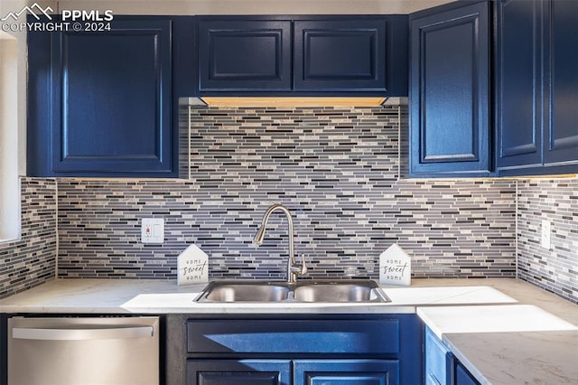 kitchen featuring tasteful backsplash, sink, stainless steel dishwasher, and blue cabinets