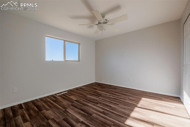 empty room with dark hardwood / wood-style floors and ceiling fan