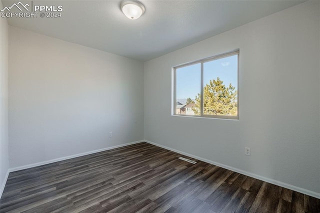 unfurnished room with dark hardwood / wood-style flooring