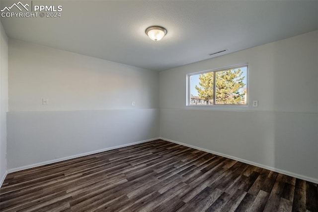 unfurnished room with dark wood-type flooring