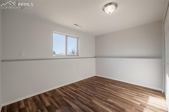 unfurnished room with hardwood / wood-style floors and lofted ceiling