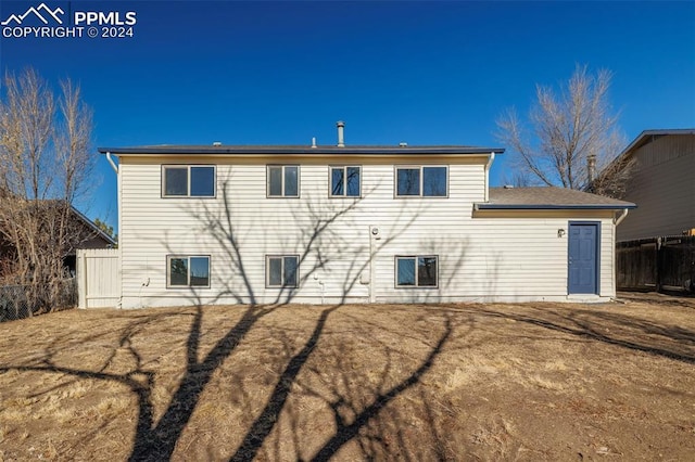 rear view of property featuring a lawn