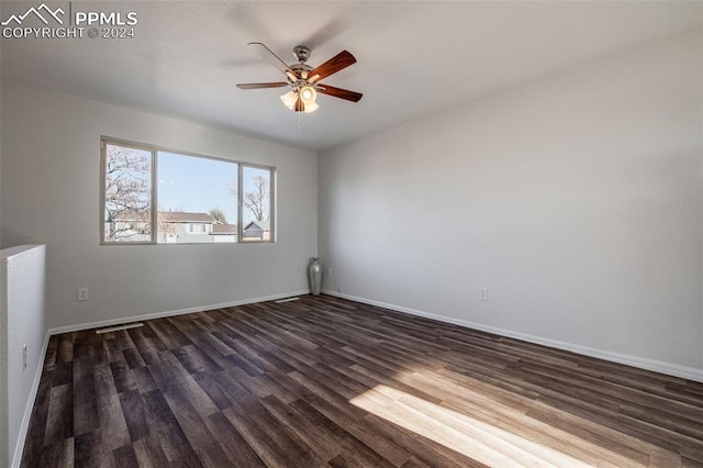 spare room featuring ceiling fan and dark wood-type flooring