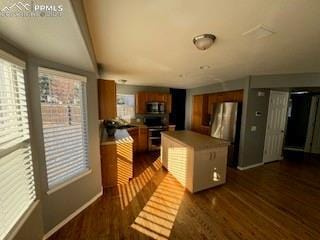 kitchen featuring stainless steel appliances, dark hardwood / wood-style flooring, and a center island