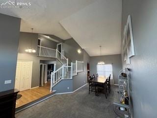 dining space with carpet floors, a notable chandelier, and vaulted ceiling