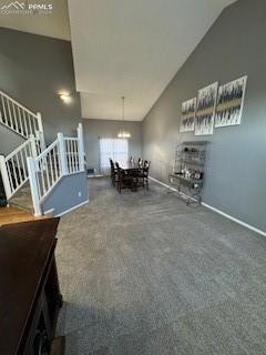 unfurnished dining area featuring carpet, lofted ceiling, and a notable chandelier