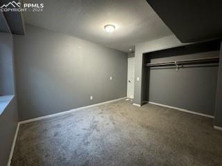 unfurnished bedroom featuring a closet and dark colored carpet