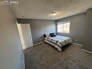 bedroom featuring a textured ceiling and dark colored carpet