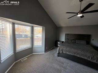 bedroom with ceiling fan, vaulted ceiling, and carpet floors