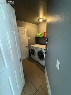 washroom featuring washing machine and dryer and light tile patterned floors