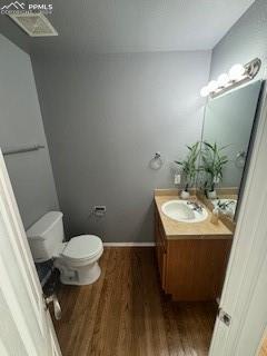 bathroom with toilet, wood-type flooring, and vanity