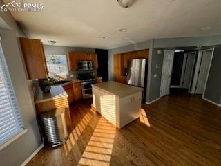 kitchen featuring stainless steel appliances, dark hardwood / wood-style flooring, and a center island