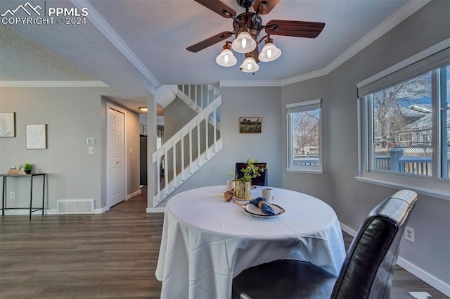 dining area featuring ornamental molding, dark hardwood / wood-style floors, ceiling fan, and a textured ceiling