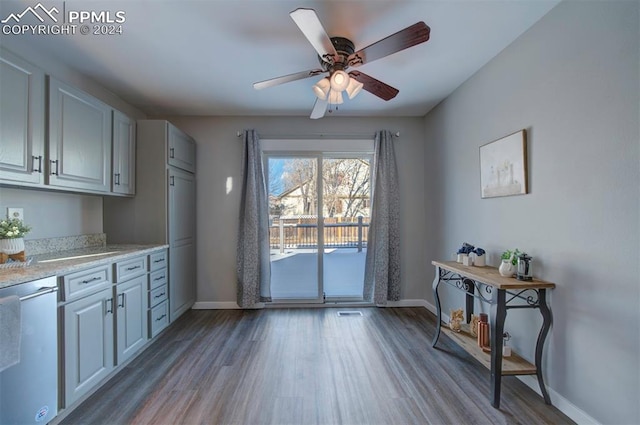 kitchen with light stone countertops, stainless steel dishwasher, light hardwood / wood-style floors, and ceiling fan