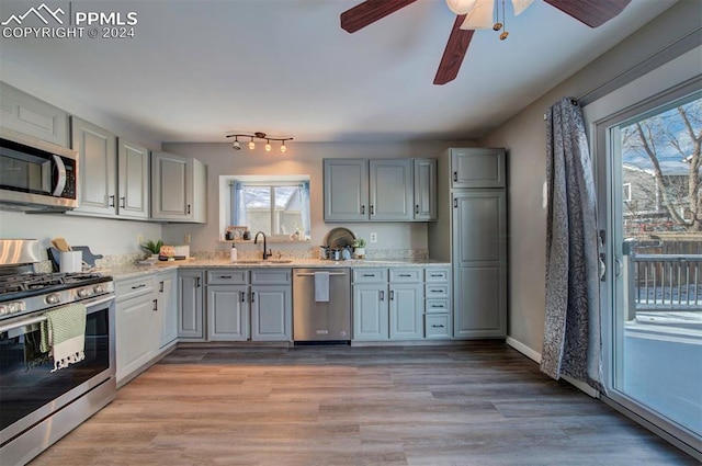 kitchen featuring light hardwood / wood-style flooring, sink, gray cabinets, and appliances with stainless steel finishes