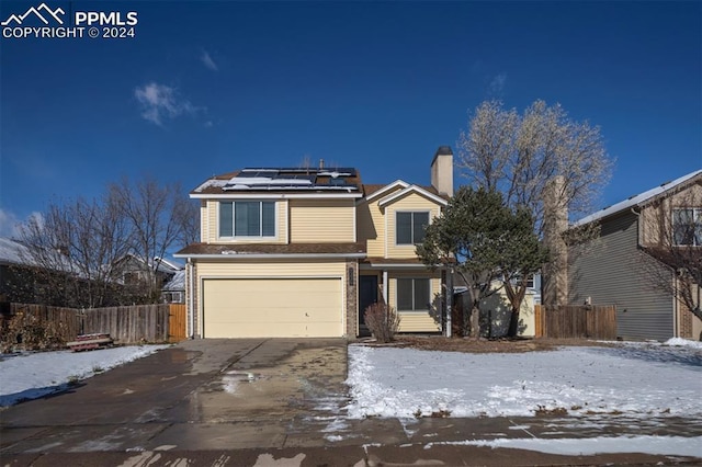 view of property featuring a garage and solar panels