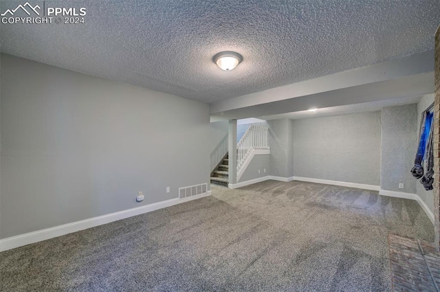 basement with a textured ceiling and carpet flooring