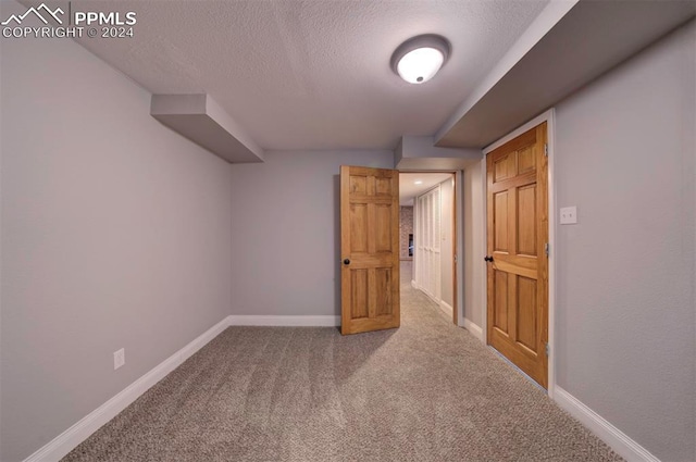 bonus room with carpet and a textured ceiling