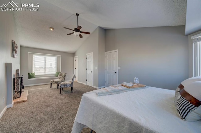 bedroom with ceiling fan, high vaulted ceiling, carpet flooring, a fireplace, and a textured ceiling