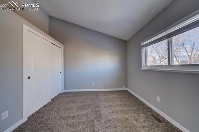 unfurnished bedroom featuring carpet flooring and a textured ceiling