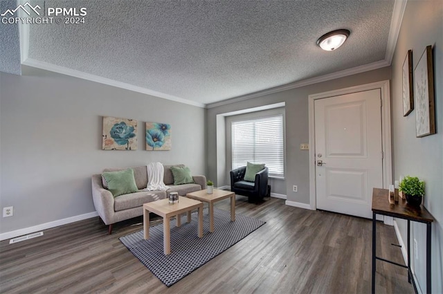 living room featuring crown molding, dark wood-type flooring, and a textured ceiling