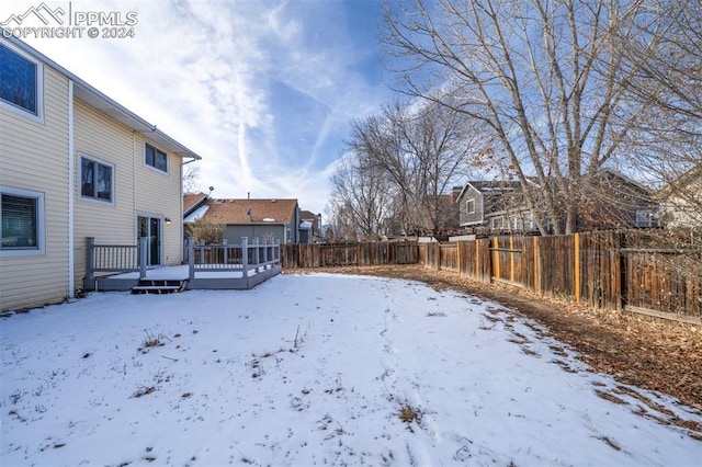 yard covered in snow featuring a deck