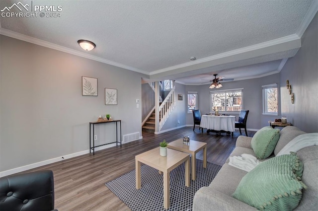 living room with crown molding, wood-type flooring, and a textured ceiling