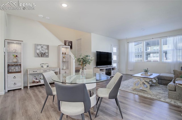 dining space featuring lofted ceiling and light wood-type flooring