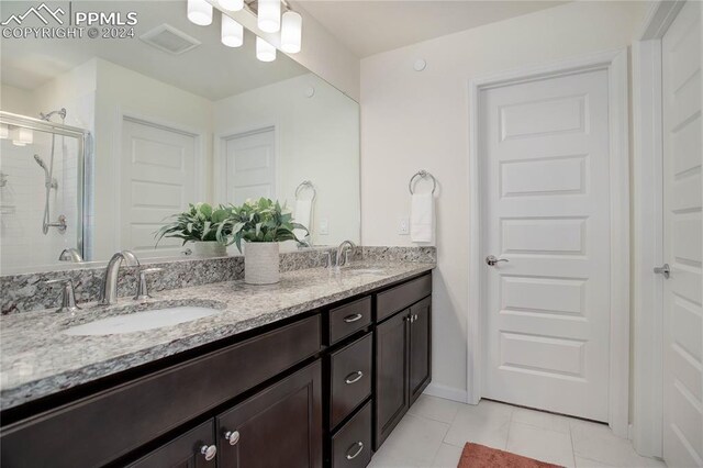 bathroom with tile patterned floors, vanity, and walk in shower