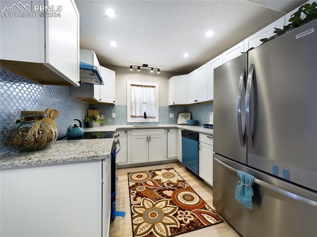 kitchen featuring light stone counters, appliances with stainless steel finishes, decorative backsplash, white cabinets, and light wood-type flooring