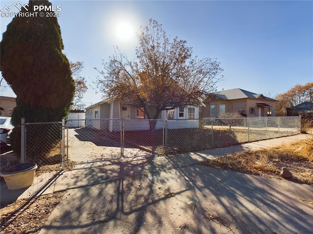 ranch-style home with a fenced front yard, a gate, and a residential view