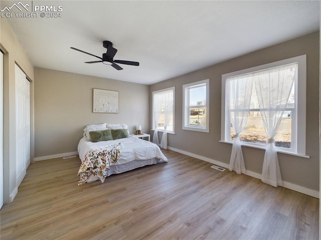 bedroom featuring ceiling fan, light wood-type flooring, and a closet