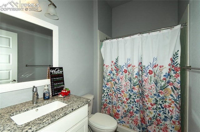 bathroom featuring walk in shower, vanity, and toilet