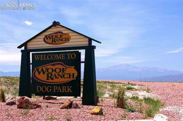 community / neighborhood sign with a mountain view