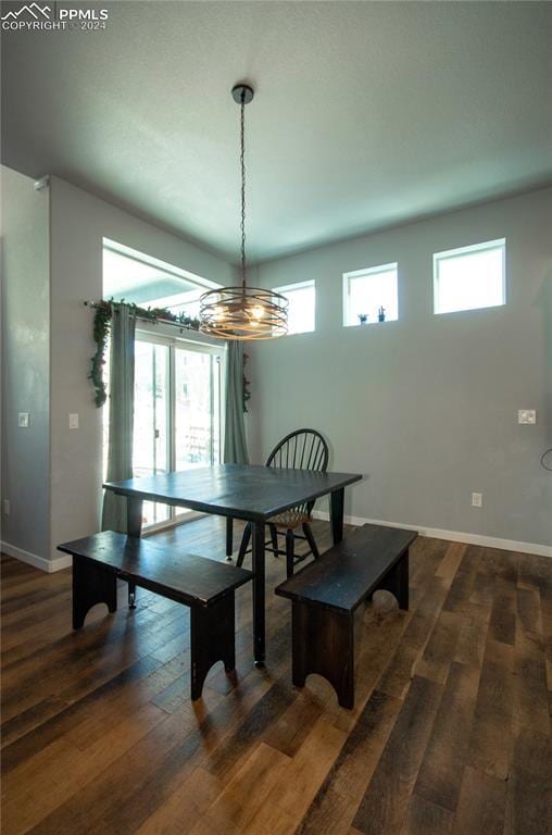 dining area with dark wood-type flooring and a chandelier