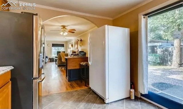 kitchen featuring stainless steel fridge, white fridge, ceiling fan, and a healthy amount of sunlight