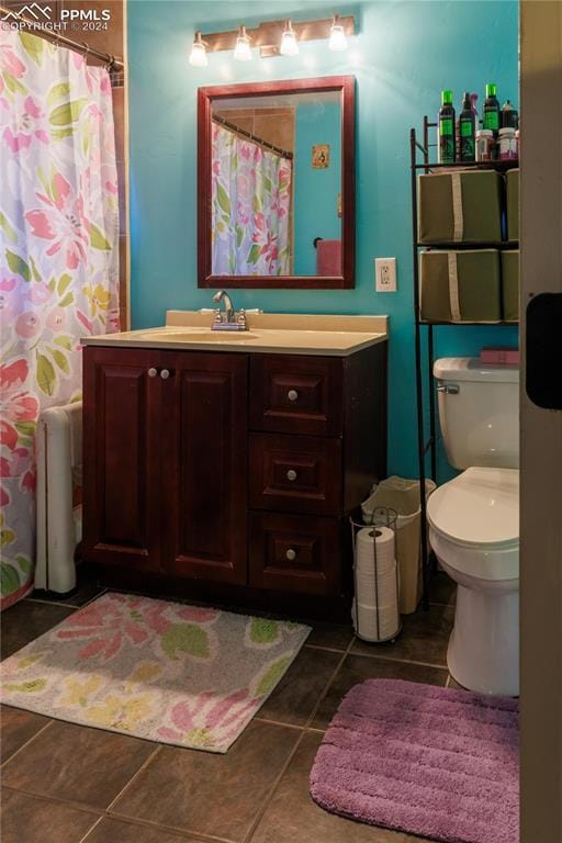 bathroom with curtained shower, vanity, and toilet