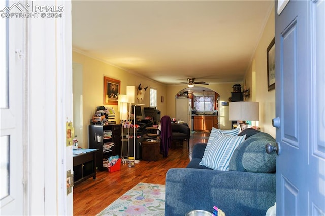 living room with ceiling fan, crown molding, and dark hardwood / wood-style floors