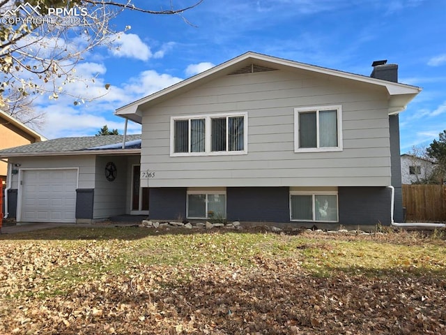 tri-level home with a front yard and a garage